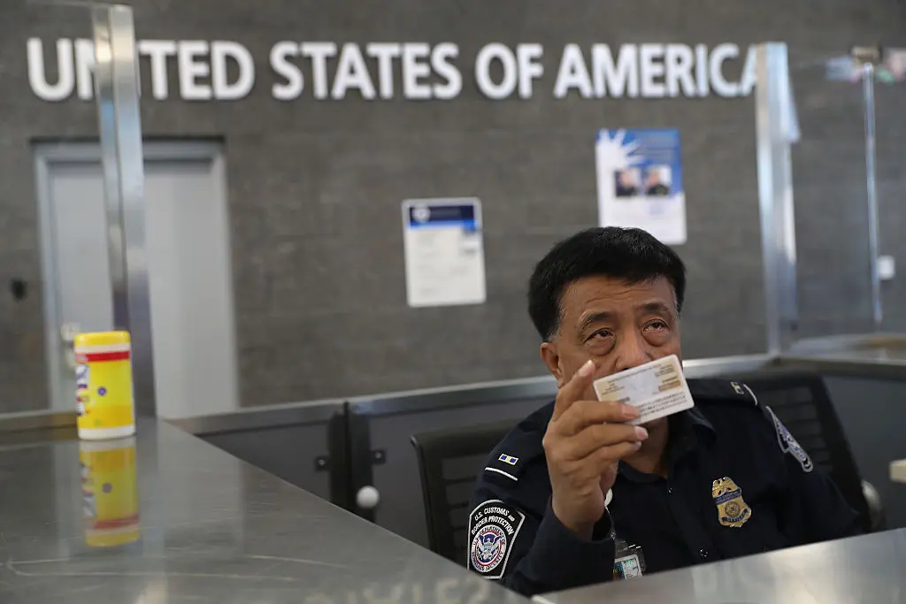 中国男隐瞒党籍赴美 机场秒捕震动华人圈 示意图。图为美国一海关人员在检查入境游客的证件。(John Moore/Getty Images)